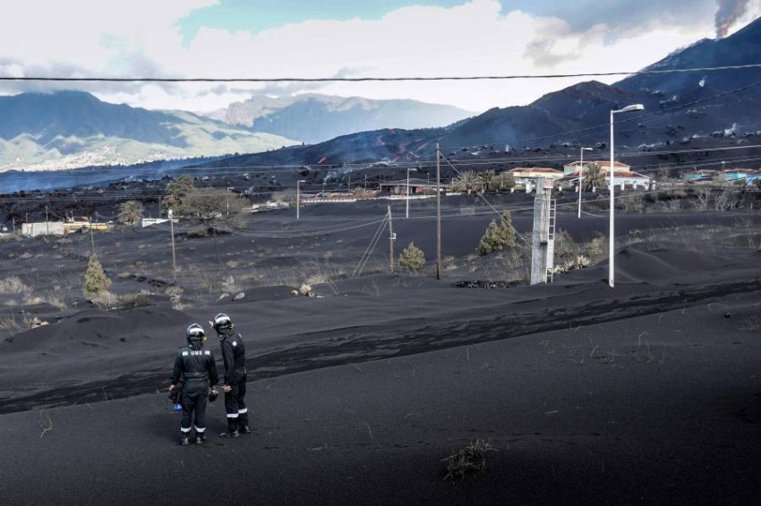 In this handout photograph taken on November 19, 2021 and released by the Spanish Military Emergency Unit (UME) on November 20, members of the UME monitor gas emissions in an ash-covered area of Las Manchas, following the eruption of the Cumbre Vieja volcano on the Canary island of La Palma. - It has been two months since Cumbre Vieja began erupting, forcing more than 6,000 people out of their homes as the lava burnt its way across huge swathes of land on the western side of La Palma. (Photo by Luismi Ortiz / various sources / AFP) / RESTRICTED TO EDITORIAL USE - MANDATORY CREDIT "AFP PHOTO / LUISMI ORTIZ / SPANISH MILITARY UNIT (UME)" - NO MARKETING - NO ADVERTISING CAMPAIGNS - DISTRIBUTED AS A SERVICE TO CLIENTS
