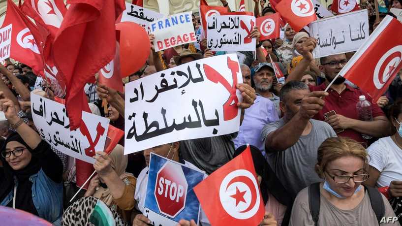 Demonstrators chant slogans during a protest in Tunisia's capital Tunis on September 26, 2021, against President Kais Saied's recent steps to tighten his grip on power. - Saied had on July 25 sacked prime minister Hichem Mechichi, suspended parliament and granted himself judicial powers. On September 22 he also announced "exceptional measures" that allow him to rule by decree. (Photo by FETHI BELAID / AFP)