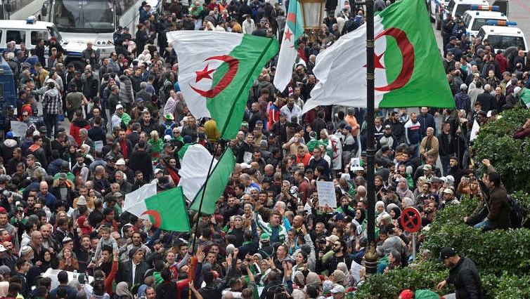 Algerian protesters wave national flags during an anti-government demonstration in the capital Algiers, on December 20, 2019. - Establishment insider Abdelmadjid Tebboune was sworn in yesterday as Algeria's new president, a week after winning elections marred by mass protests and record abstention. He succeeds ousted veteran leader Abdelaziz Bouteflika, and must now address the grievances of the protesters, who have remained on the streets to prevent what they see as a ploy by the political elite to retain its hold on power. (Photo by RYAD KRAMDI / AFP)