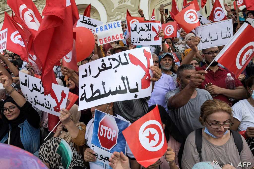 Demonstrators chant slogans during a protest in Tunisia's capital Tunis on September 26, 2021, against President Kais Saied's recent steps to tighten his grip on power. - Saied had on July 25 sacked prime minister Hichem Mechichi, suspended parliament and granted himself judicial powers. On September 22 he also announced "exceptional measures" that allow him to rule by decree. (Photo by FETHI BELAID / AFP)