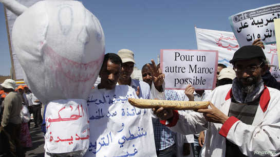Demonstrators hold an effigy of the devil (L) and placards during a rally against rising prices in Rabat June 10, 2012. REUTERS/Stringer (MOROCCO - Tags: POLITICS CIVIL UNREST)