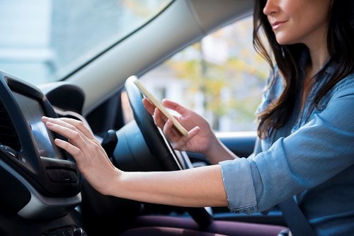 Caucasian woman in car holding cell phone programming journey