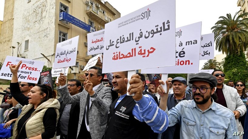Tunisian journalists hold signs during a protest demanding press freedom outside the National Syndicate of Tunisian Journalists (SNJT) in Tunis on May 5, 2022. - Tunisia has dropped 21 places in the World Press Freedom index for the year 2022, from 73rd to 94th place out of 180 countries. The index is published by Reporters Without Borders (RSF) to assess the state of journalism across the globe. (Photo by FETHI BELAID / AFP)
