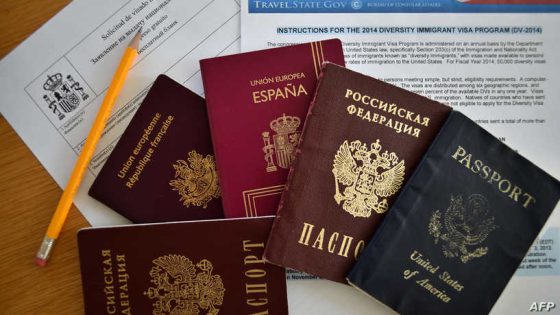 TO GO WITH AFP STORY A picture taken in Moscow on July 31, 2014, shows Russian, US, Spanish an British passports laying together with visa application forms. A new law goes into effect this week requiring Russians to declare to the authorities if they have the citizenship of another country, a measure that has sparked angst in a state with a long history of repression. AFP PHOTO