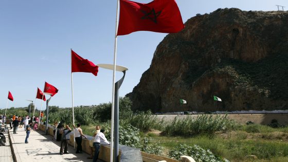 People stand near a border post on the Algerian side of the Morocco-Algeria border in the north east of Morocco July 31, 2011. Morocco's King Mohammed renewed calls on Saturday to normalise ties and reopen borders with wealthier neighbour Algeria, saying that Rabat wants to build an integrated North African economic bloc. Morocco closed the border following a 1994 Islamist militant attack in Marrakesh, which it blamed on Algeria's secret service, and the border region remains tense. REUTERS/Youssef Boudlal (MOROCCO - Tags: POLITICS)
