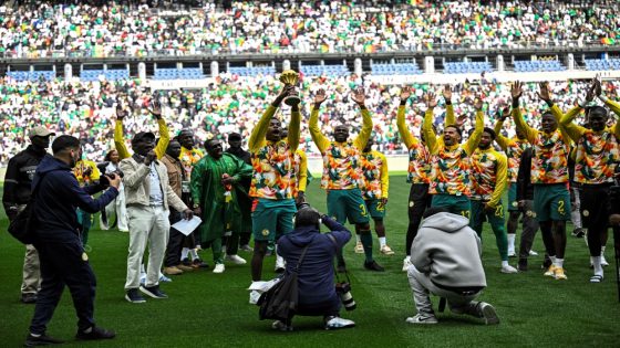 Senegal's players parade with The African Cup of Nations trophy ahead of the international friendly football match between Senegal and Peru at the Stade de France in Saint-Denis, north of Paris on March 28, 2026. (Photo by JULIEN DE ROSA / AFP)